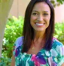 A headshot of Amanda Champlin, a middle-aged woman wearing a floral shirt.