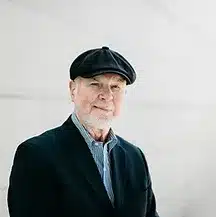 A headshot of Jim Morgan, an old man wearing a newsboy cap.