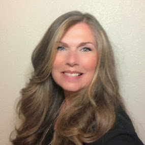A headshot of Jenny Sales, a woman with thick, gently curled light brown hair.